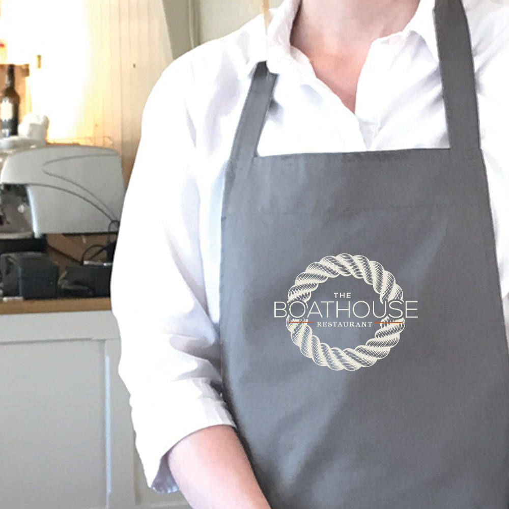 Grey apron branded with The Boathouse logo
